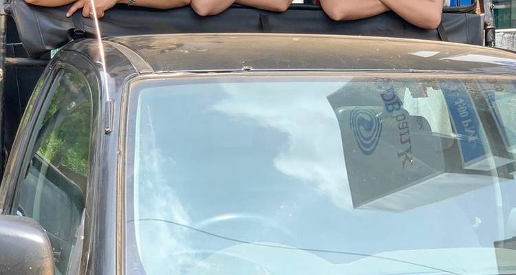 Group of friends celebrating on a beach with ocean waves.
