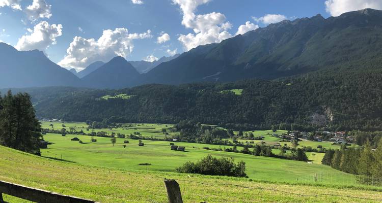 Malerische Aussicht auf ein Alpental mit Bergen im Hintergrund.