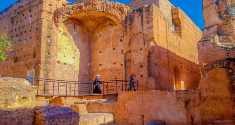 Des visiteurs explorant des ruines antiques sous un soleil éclatant.
