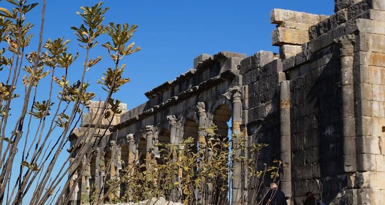 Side view of ancient stone ruins with clear blue sky.