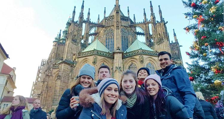 Group of tourists in front of a Gothic cathedral during a festive time.