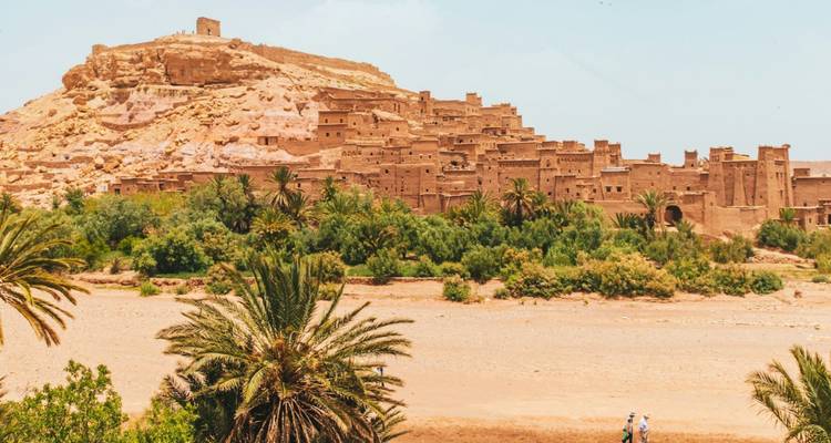 Aït-Ben-Haddou, un village fortifié historique avec des bâtiments en terre entouré d'un paysage désertique.
