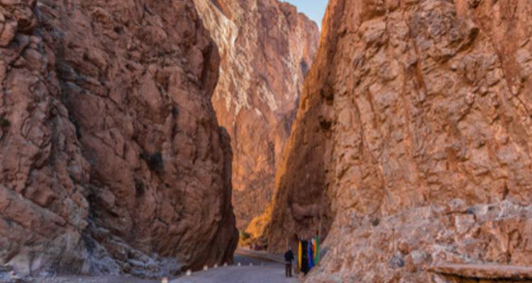 Un canyon étroit avec de hautes parois rocheuses et deux personnes qui marchent.