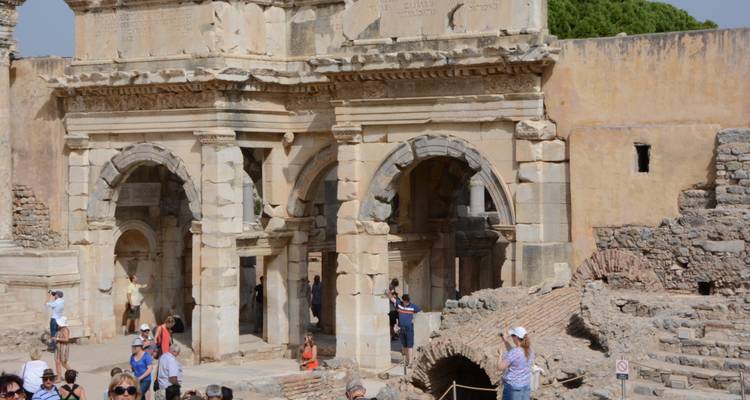 People exploring a monumental Roman archway.