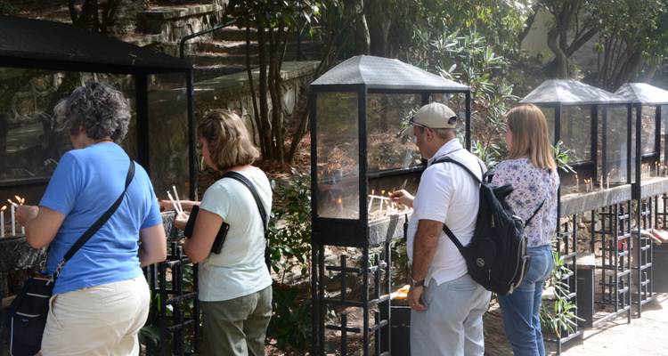 People lighting candles at a religious or cultural site.