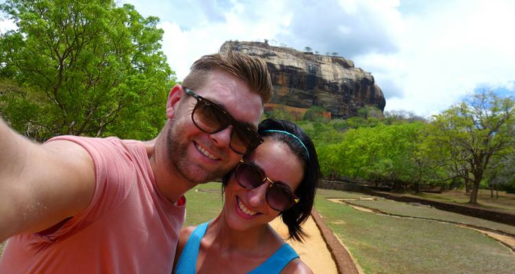 Couple prenant un selfie avec la formation rocheuse de Sigiriya en arrière-plan.