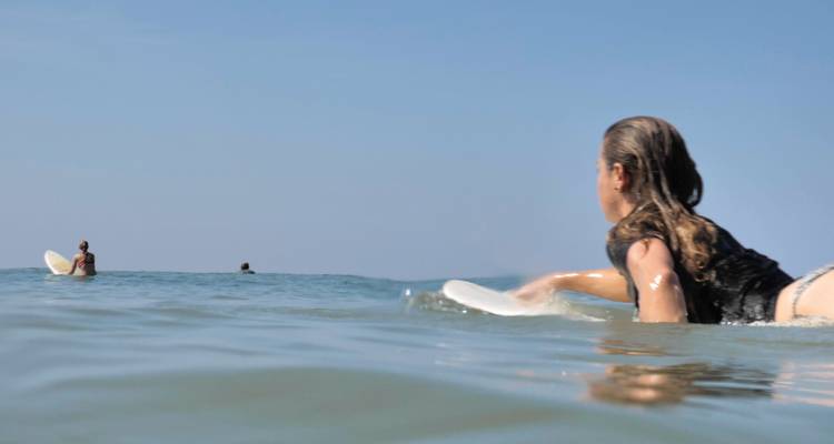 Des gens qui surfent sur les vagues, pris sous un angle bas dans l'eau.