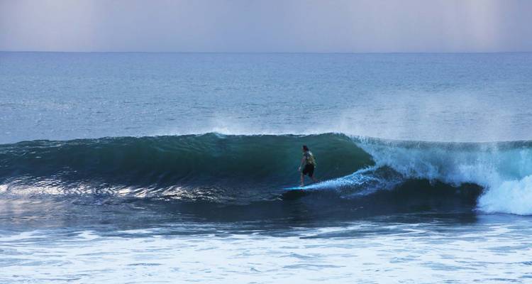 Personne faisant du surf sur une grosse vague dans l'océan.