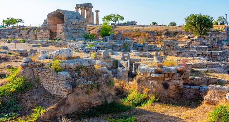 Ancient ruins in a grassy area with clear sky.