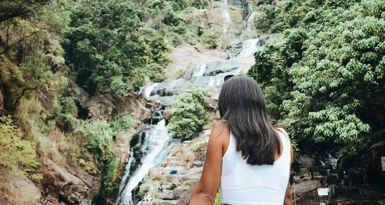 Personne devant une cascade, contemplant le paysage naturel.