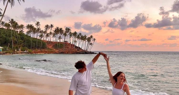 Couple dansant sur la plage pendant le coucher de soleil.