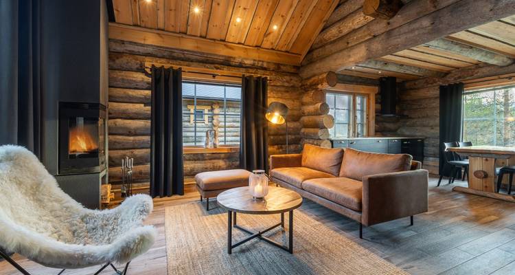 Rustic log cabin interior with a fireplace and wooden furniture.