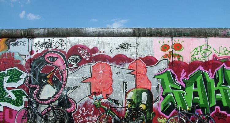 Graffitis sur le mur de Berlin avec des vélos devant.