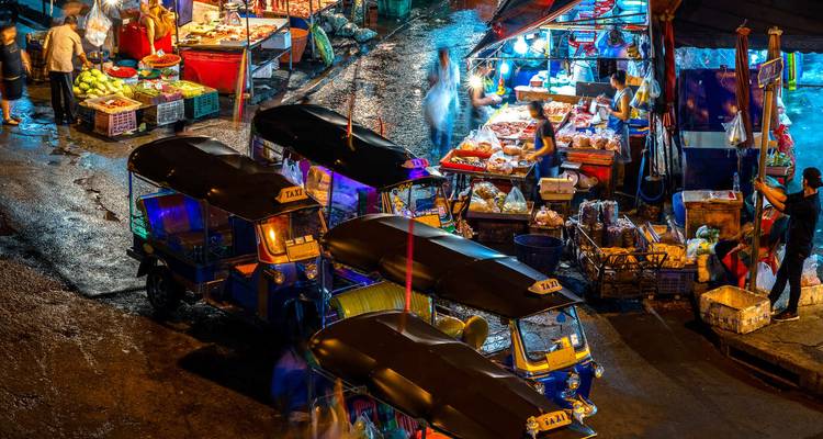 Marché nocturne animé avec des tuk-tuks et des étals de nourriture