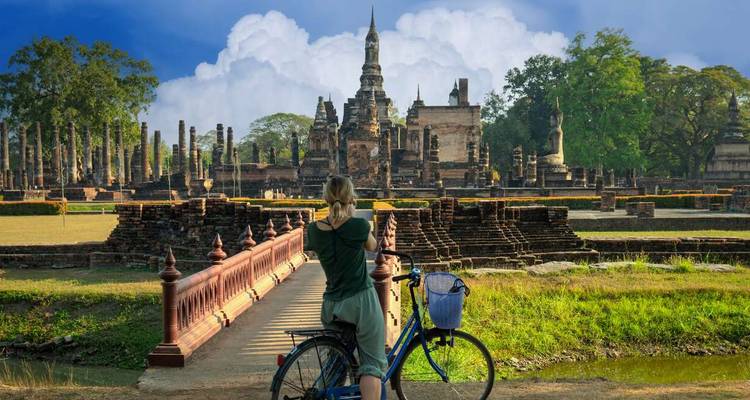 Cycliste admirant des ruines antiques dans un cadre de parc