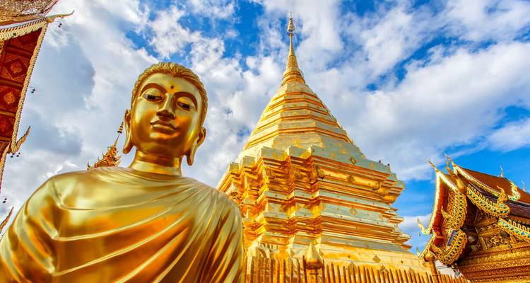 Statue dorée de Bouddha avec temple en arrière-plan