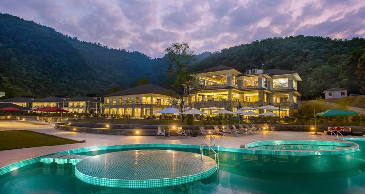 Resort de lujo con piscina al anochecer.