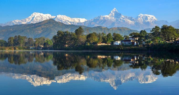 Montañas cubiertas de nieve reflejadas en un lago.