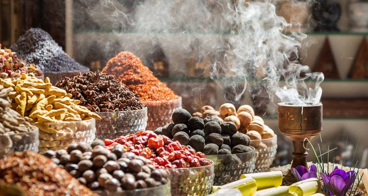 Display of various spices with smoke rising from a burner.