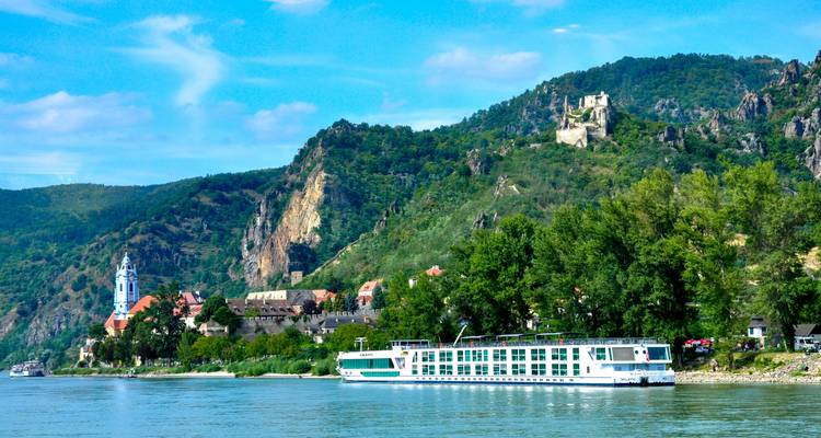 River cruise with a scenic backdrop of hills and historic buildings.