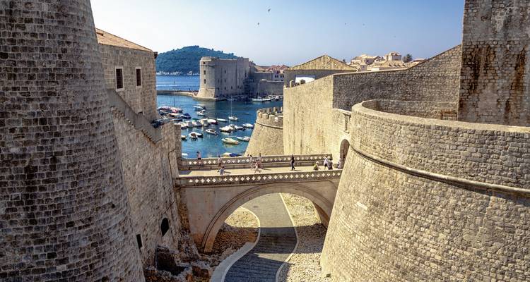 Vue des fortifications en pierre près d'un port.