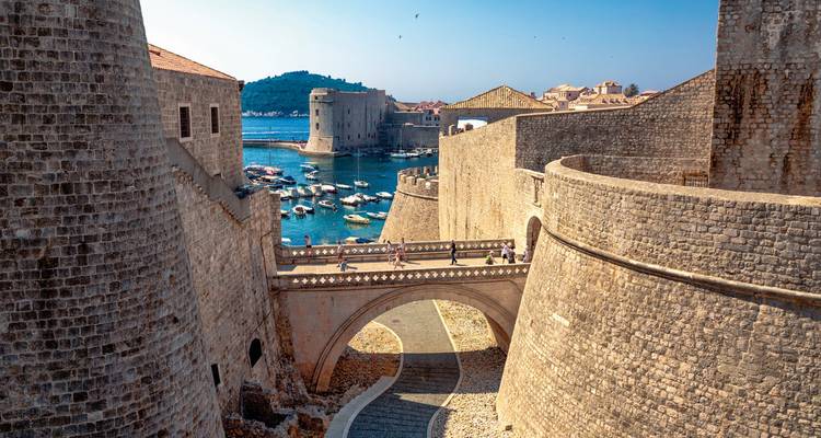 Murallas históricas y puerto de Dubrovnik con vista al océano.