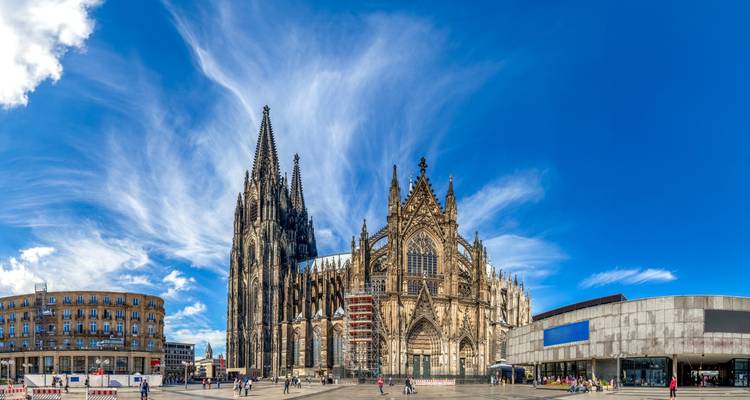 Gothic cathedral dominating an open plaza with a clear blue sky.