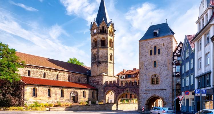 Église historique avec des flèches et une porte d'entrée médiévale.