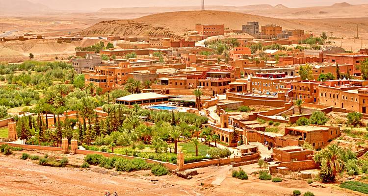 Clay-built village surrounded by lush greenery.