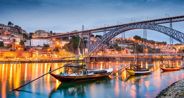 Porto's Ribeira District and Dom Luís I Bridge over the Douro River at dusk.