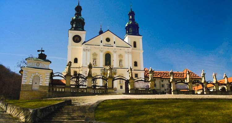 Baroque-style church with statues and blue sky.