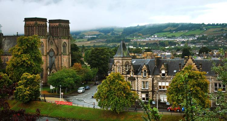 Vue d'une ville avec une architecture historique et moderne sous les nuages.