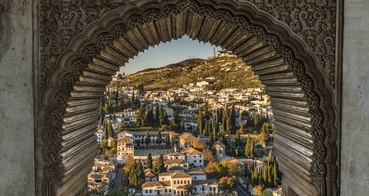 View of Alhambra through a Moorish archway in Granada, Spain.