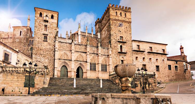 Fachada de una catedral histórica con escalones y cielos dramáticos.