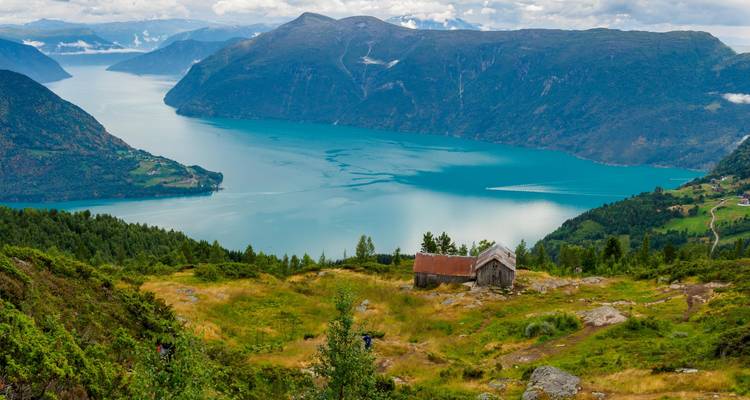 Cottage on a hill with a view of a fjord.