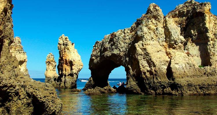 Formations rocheuses au bord de la mer avec un ciel bleu en arrière-plan.