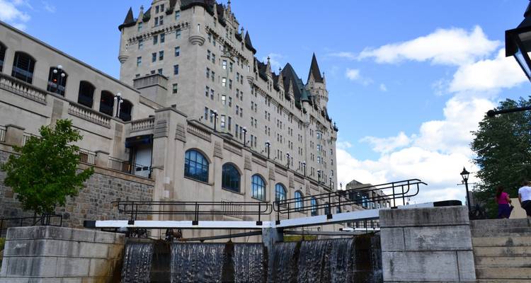 Historisches schlossähnliches Hotel neben funktionierenden Schleusen mit herabstürzendem Wasser in Ottawa.