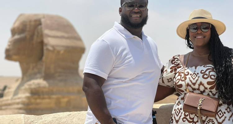Pareja posando con la Esfinge de fondo, sonriendo.