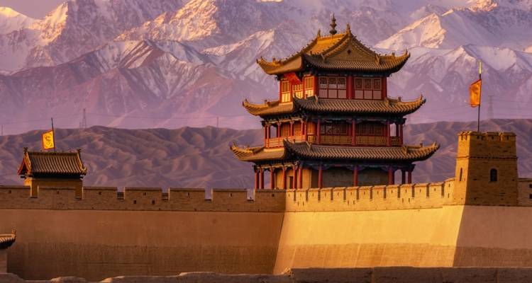 A fortified structure with mountains in the background.