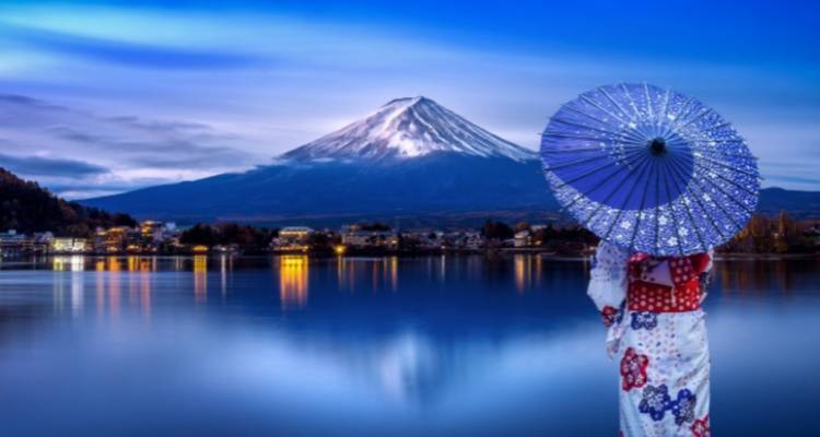 Femme en tenue traditionnelle avec une vue du mont Fuji au-dessus d'un lac.