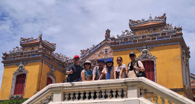 Groupe de touristes posant devant un bâtiment traditionnel.