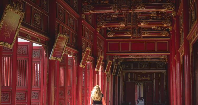 Personne marchant dans un couloir richement décoré.