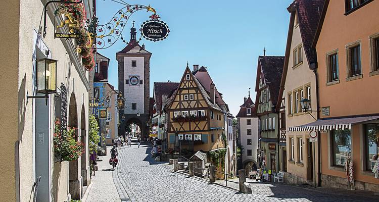 Een charmante geplaveide straat met historische gebouwen op een zonnige dag.