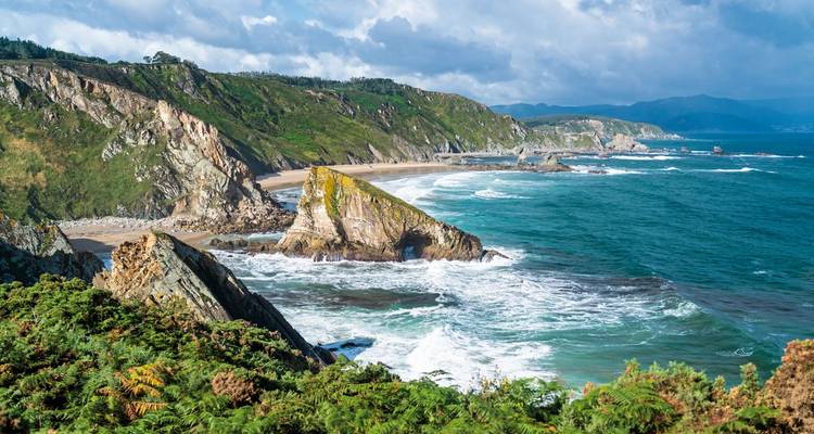 Küstenlinie mit Klippen und Meereswellen.