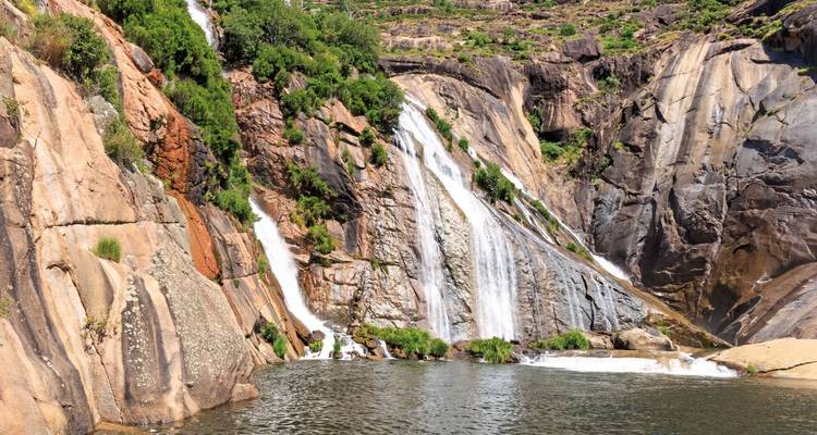 Wasserfälle, die an felsigen Klippen hinunterfließen.