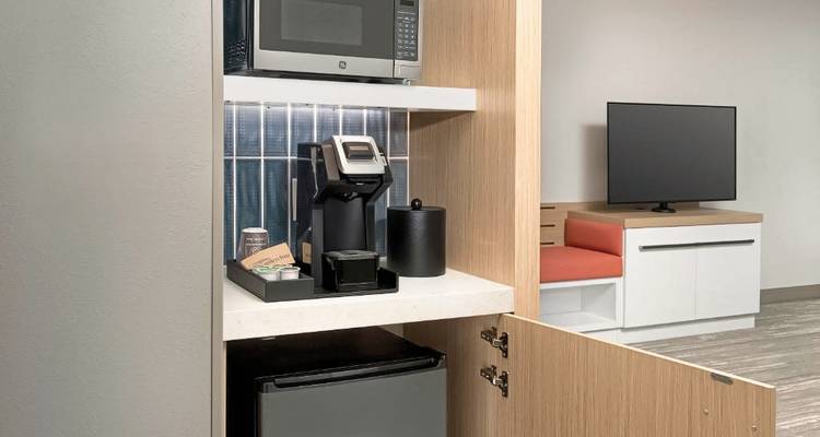 Équipements de chambre d'hôtel incluant un micro-ondes, une cafetière et une télévision.