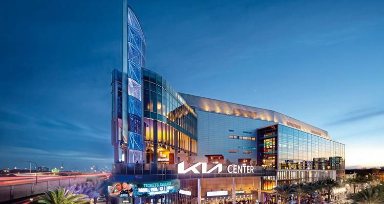 Vue extérieure d'une arène urbaine moderne illuminée le soir.