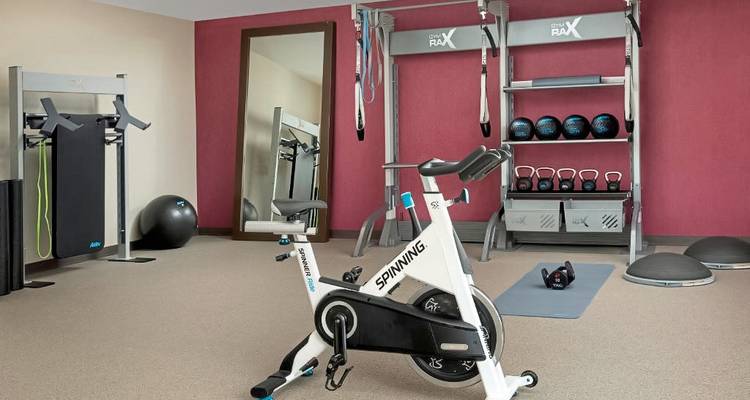 Zone de gym d'hôtel équipée de divers équipements de fitness modernes.