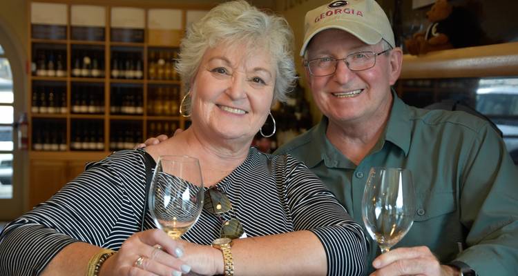 Couple savourant un verre dans une cave à vin.