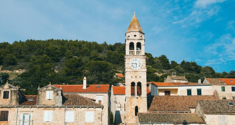 Torre del reloj de piedra contra un cielo azul.